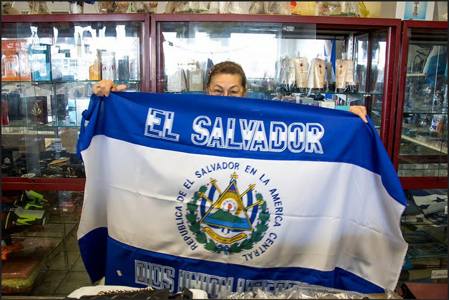 Delia Romero sosteniendo la bandera de El Salvador